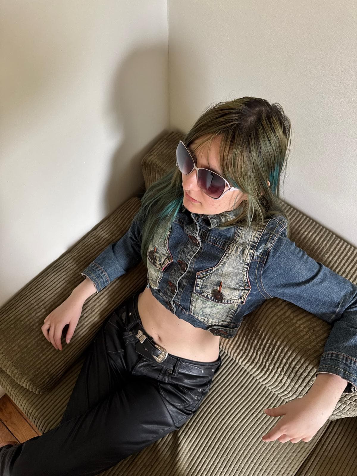 Veste en jean courte et délavée portée avec un pantalon en cuir noir